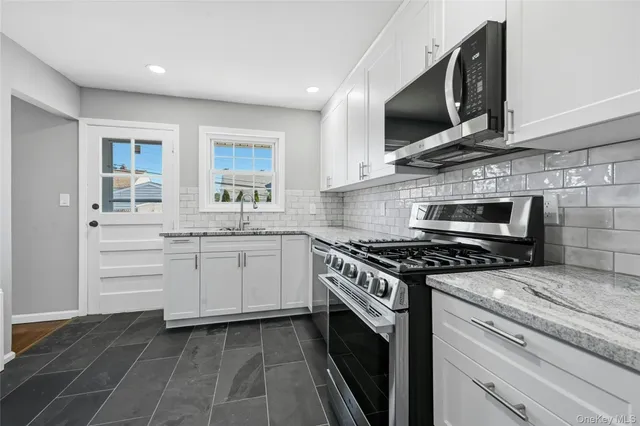 a kitchen with cabinets stainless steel appliances and a sink