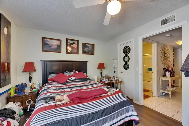 a bedroom with a bed and a flat tv screen on the dresser