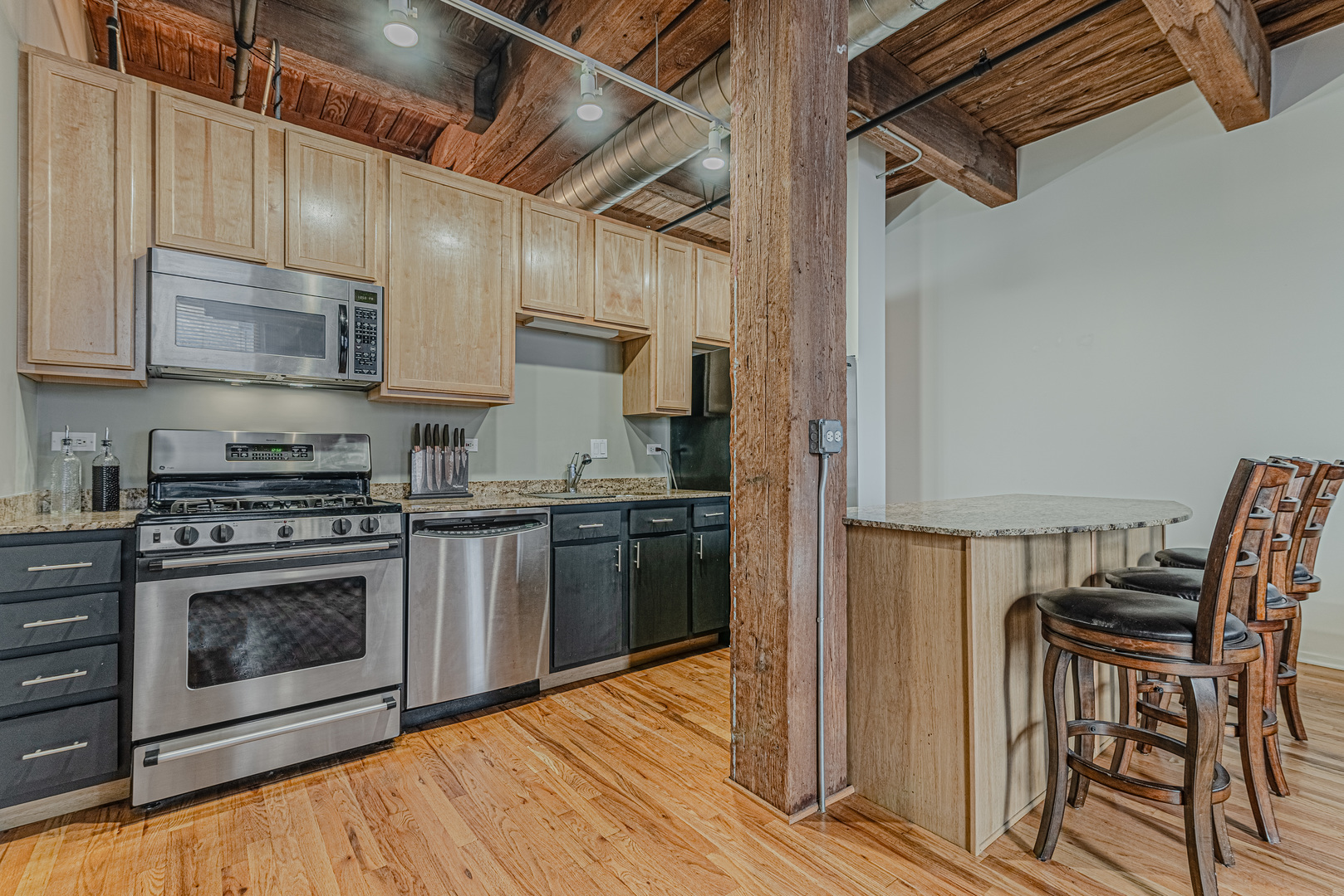1500 West Monroe Street, Unit 517 Chicago, IL 60607 - Photo 7 of 26 a kitchen with stainless steel appliances granite countertop a stove top oven a sink and cabinets