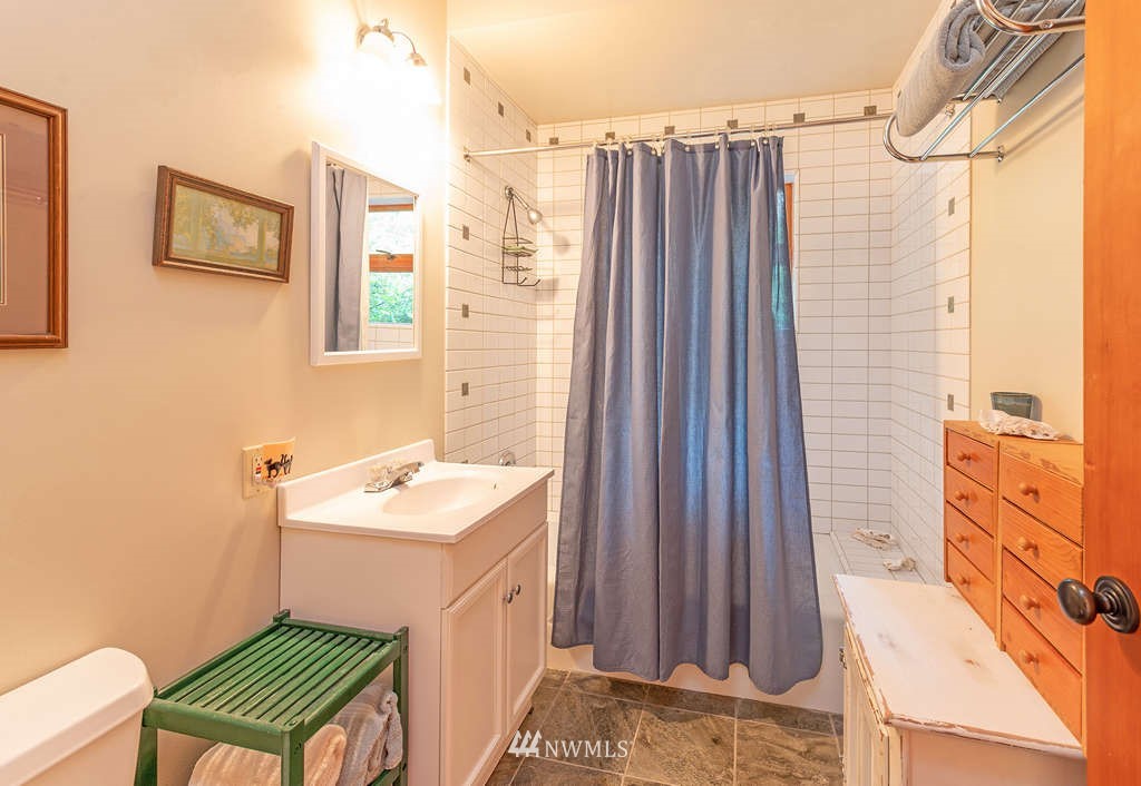 18132 Thorsen Road Southwest Vashon, WA 98070 - Photo 27 of 40 a bathroom with a sink a mirror and a shower