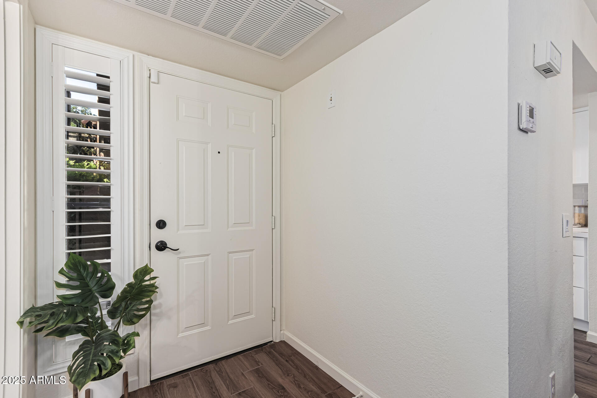 8700 East Mountain View Road, Unit 1039 Scottsdale, AZ 85258 - Photo 8 of 37 a view of a hallway with wooden floor and a potted plant