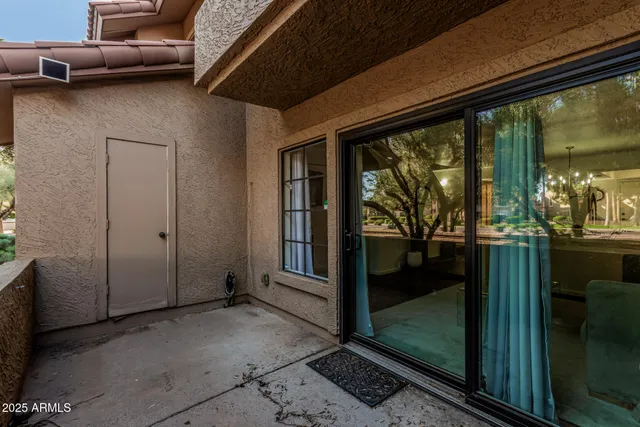 a bedroom with a bed large window with table and chair
