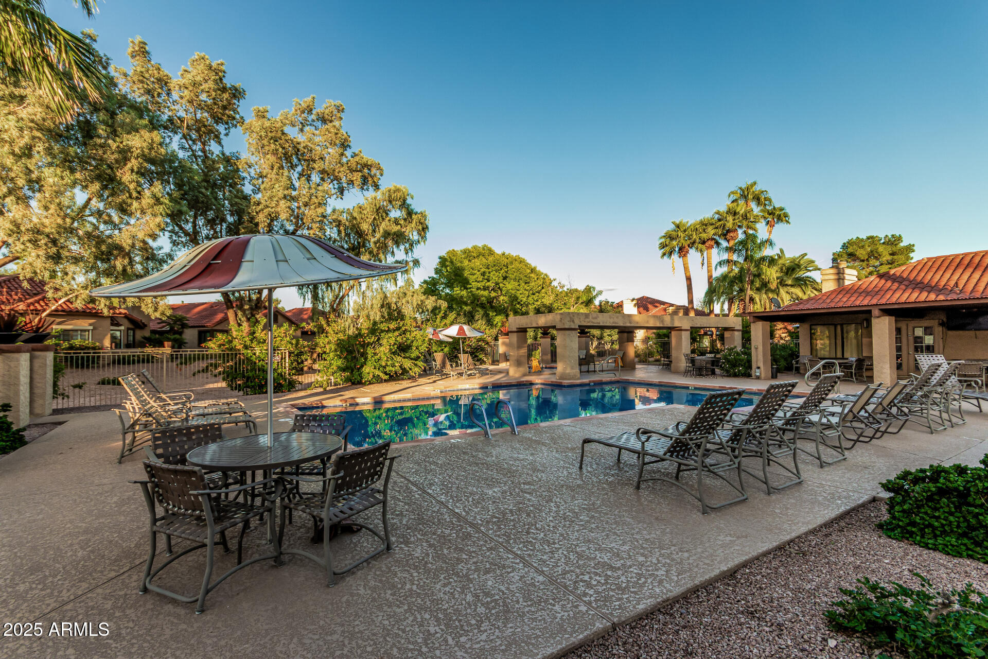 8700 East Mountain View Road, Unit 1039 Scottsdale, AZ 85258 - Photo 32 of 37 a view of a patio with table and chairs potted plants with wooden fence