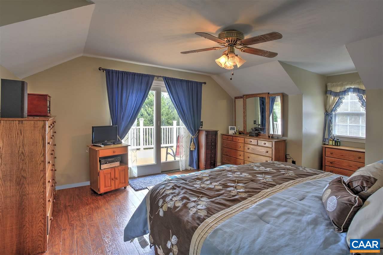 64 Horseshoe Hill Road Ruckersville, VA 22968 - Photo 11 of 33 a bedroom with a large bed and a chandelier