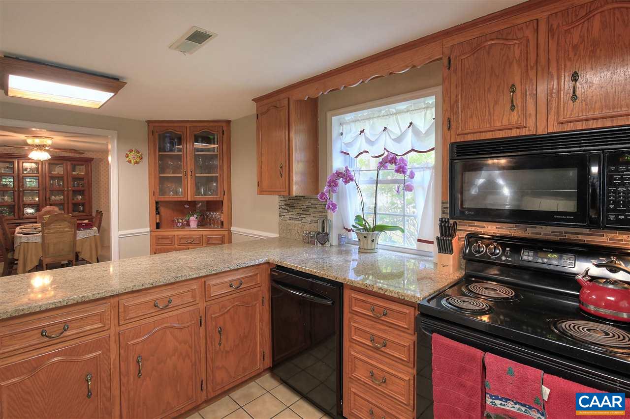 64 Horseshoe Hill Road Ruckersville, VA 22968 - Photo 7 of 33 a kitchen with stainless steel appliances wooden cabinets and a stove top oven