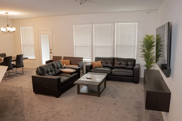a living room with furniture and kitchen view