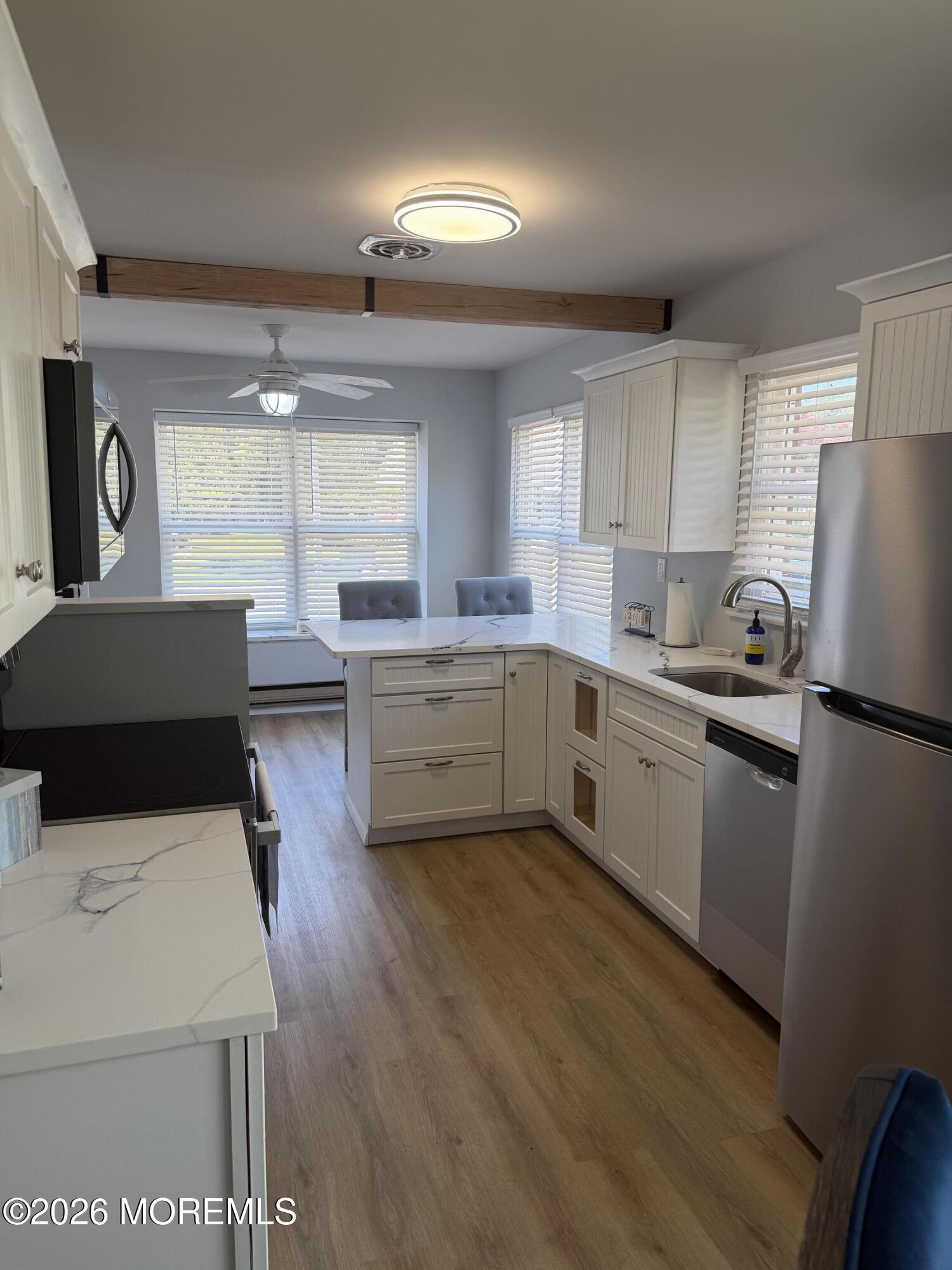 31 Homestead Drive, Unit A Whiting, NJ 08759 - Photo 16 of 23 a kitchen with a sink a stove a refrigerator and white cabinets