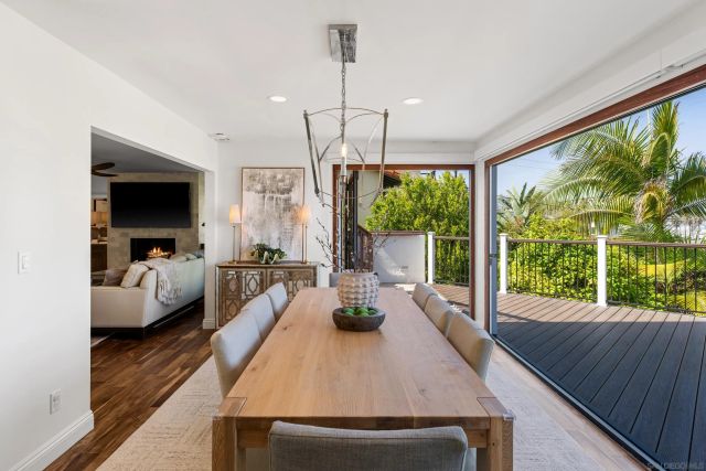 a living room with furniture two large windows and a wooden floor