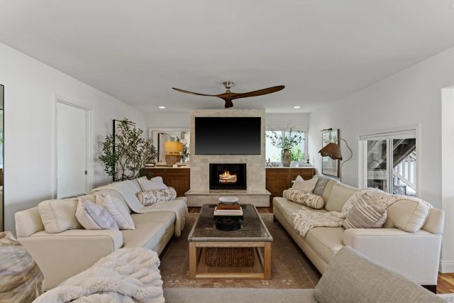 a living room with furniture a fireplace and a chandelier