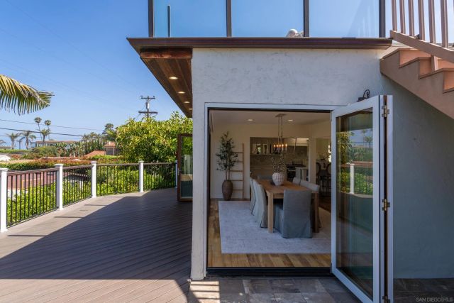 a view of a patio with table and chairs with wooden floor and fence