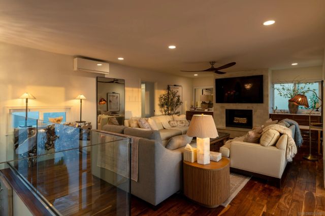 a living room with furniture a flat screen tv and kitchen view