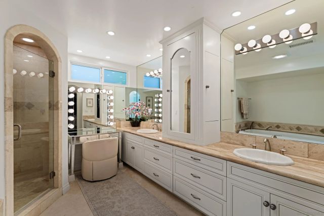 a bathroom with a granite countertop sink mirror and a shower