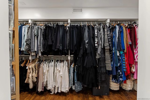 a view of walk in closet with clothes and shoes