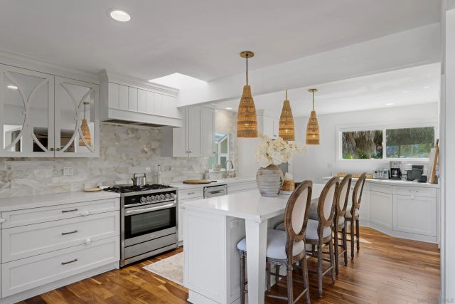 a kitchen that has a stove a table and chairs in it