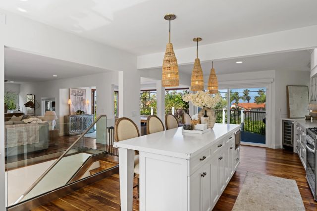 a dining room with furniture a chandelier and wooden floor