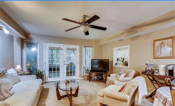 a living room with furniture a flat screen tv and a large window