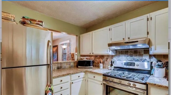a kitchen with a refrigerator and a stove top oven