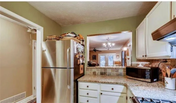 a kitchen with refrigerator and cabinets