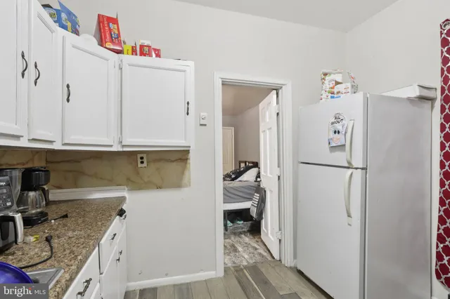 a kitchen with granite countertop a refrigerator and a sink
