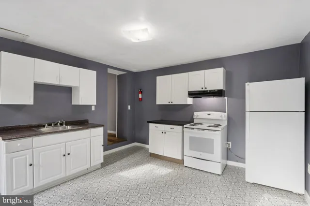 a kitchen with a stove top oven and cabinets