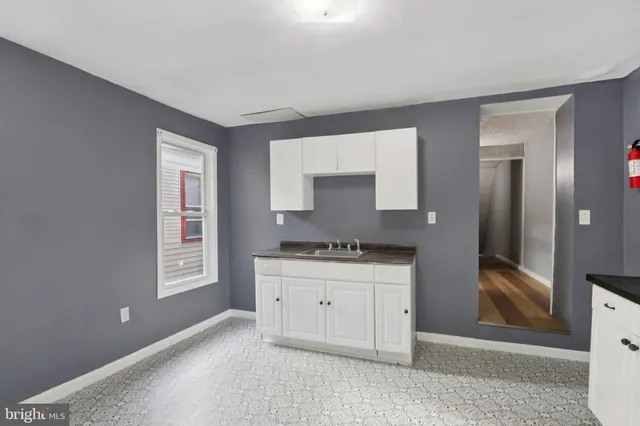 a kitchen with granite countertop a stove a sink and a refrigerator