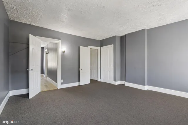 an empty room with windows and closet