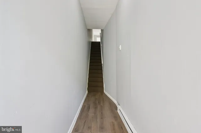 a view of a hallway with wooden floor and entryway