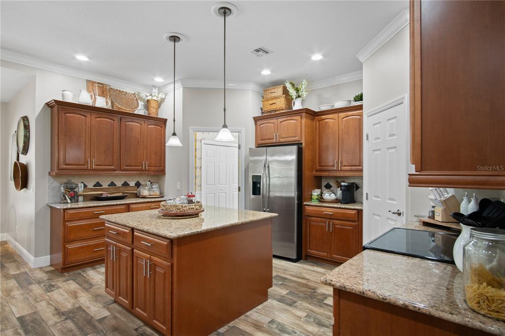 9045 Lake Hatchineha Road Kissimmee, FL 34759 - Photo 19 of 47 a kitchen with stainless steel appliances granite countertop a stove top oven a sink and a refrigerator