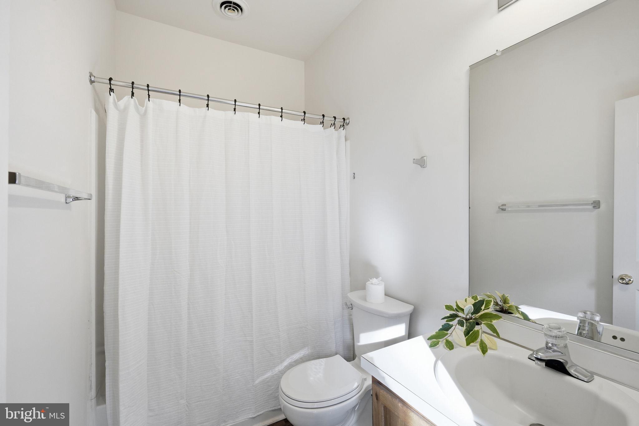 21103 Striper Run Rock Hall, MD 21661 - Photo 14 of 20 a bathroom with a sink a toilet and shower curtain