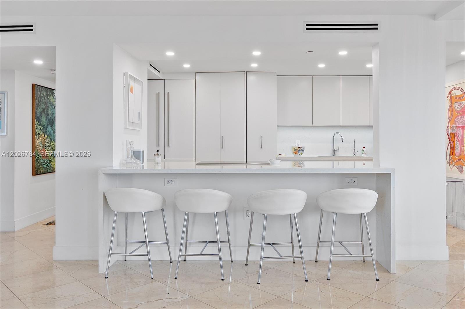 151 Southeast 15th Road, Unit 601 Miami, FL 33129 - Photo 13 of 36 a kitchen with a sink cabinets and dining table