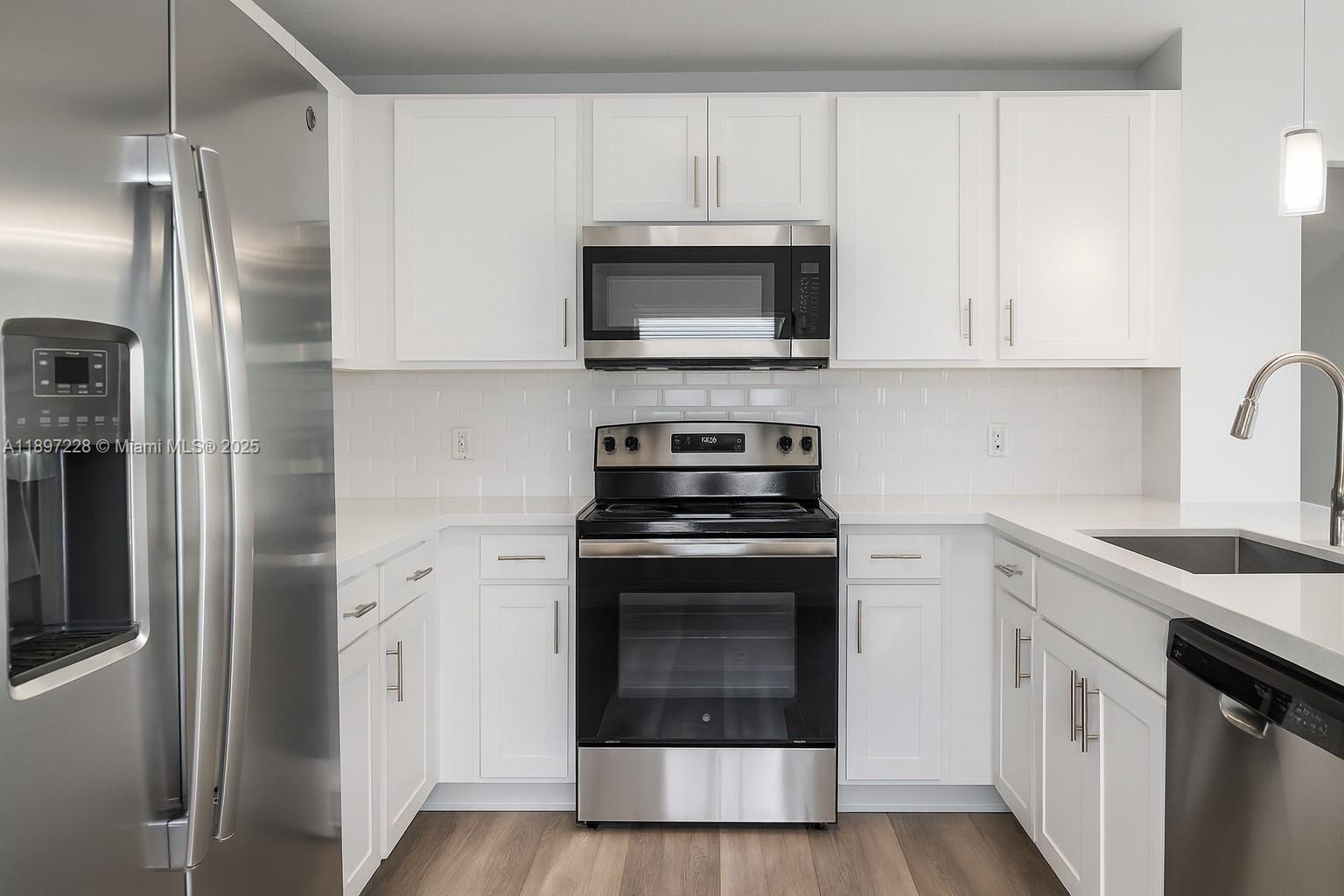 432 21st Street, Unit 432 West Palm Beach, FL 33407 - Photo 3 of 14 a kitchen with stainless steel appliances granite countertop a stove a microwave and a refrigerator