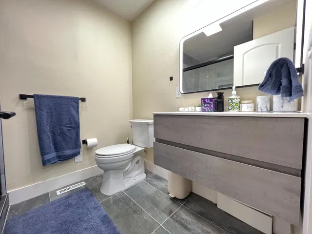 a bathroom with a toilet a sink and mirror