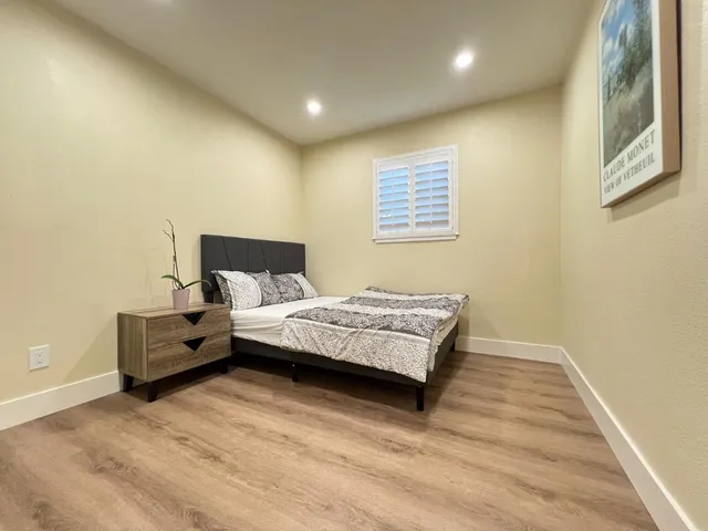a bedroom with a bed and wooden floor