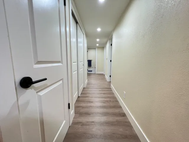 a view of a hallway with wooden floor