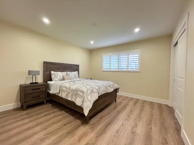 a bedroom with a bed and wooden floor