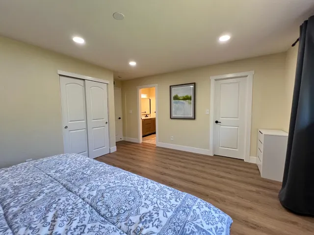 a big room with wooden floor and bathroom