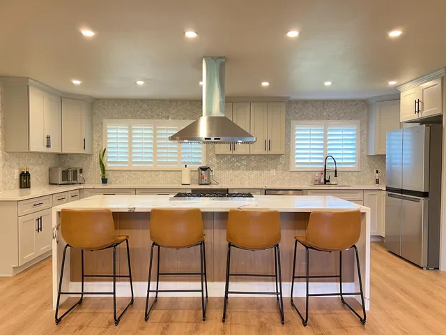 a kitchen with granite countertop white cabinets and stainless steel appliances