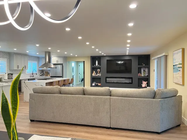 a living room with furniture kitchen and a chandelier