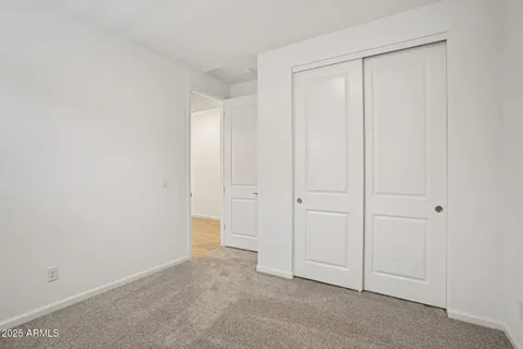 an empty room with ceiling fan and windows