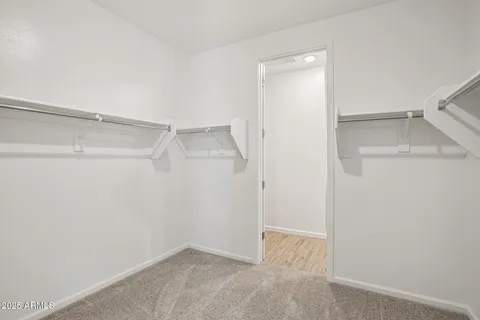a view of an empty room with wooden floor and fence
