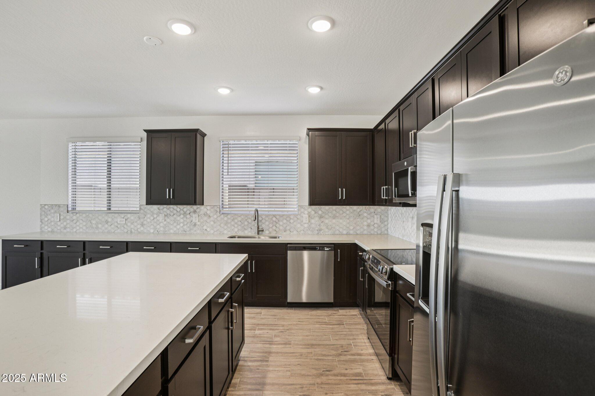 15723 West Brown Street Waddell, AZ 85355 - Photo 8 of 51 a kitchen with stainless steel appliances granite countertop a sink stove and refrigerator