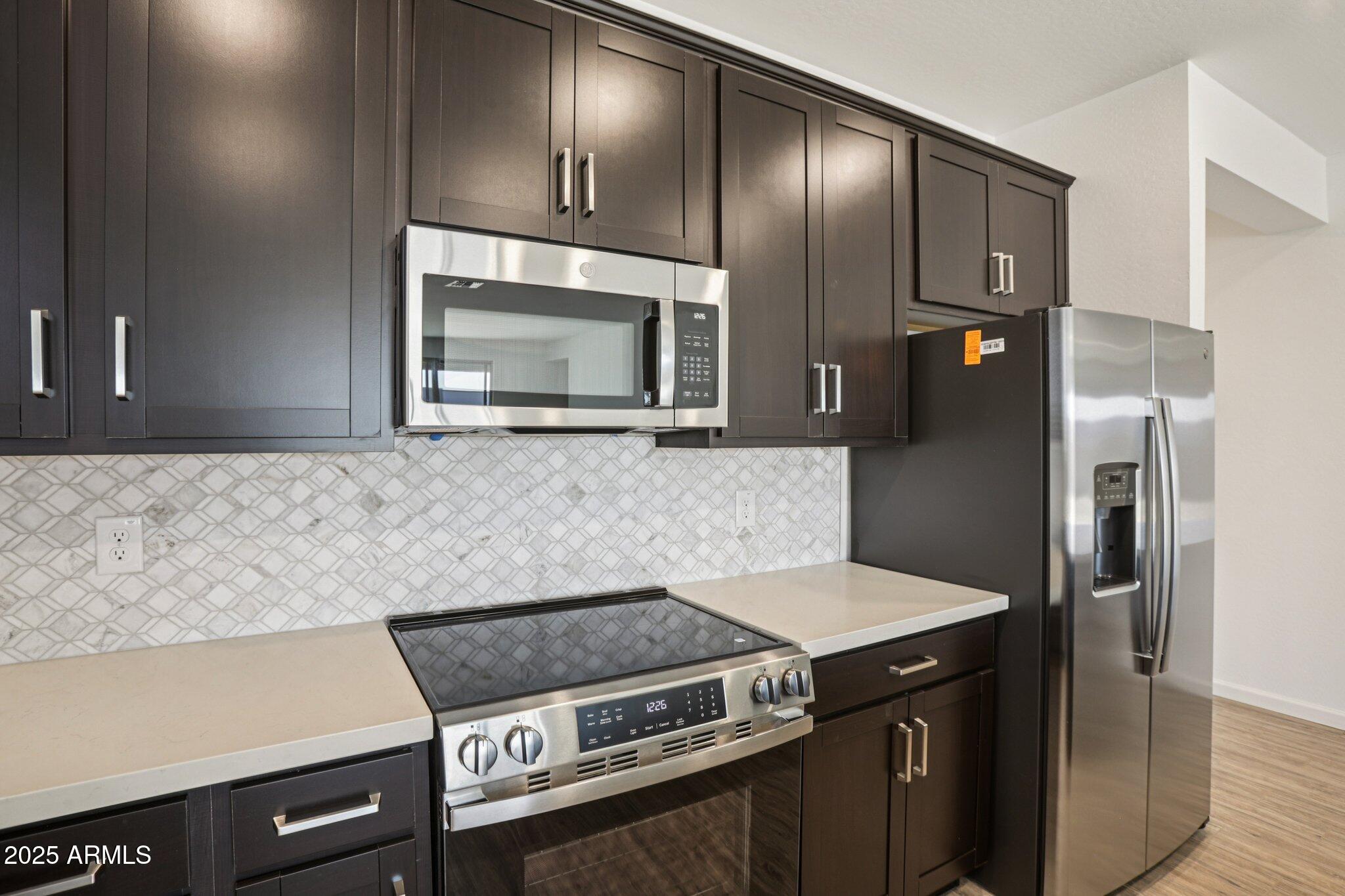 15723 West Brown Street Waddell, AZ 85355 - Photo 9 of 51 a kitchen with a stove and a microwave