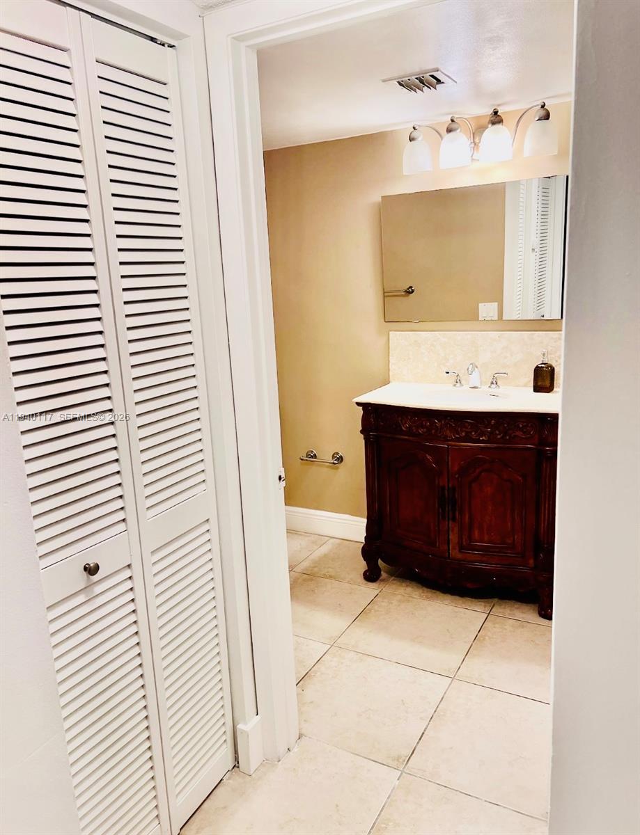 5654 Rock Island Road, Unit 214 Tamarac, FL 33319 - Photo 23 of 26 a bathroom with a sink and a mirror