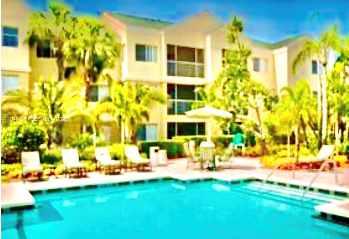 5654 Rock Island Road, Unit 214 Tamarac, FL 33319 - Photo 5 of 26 a view of a swimming pool with a lawn chairs