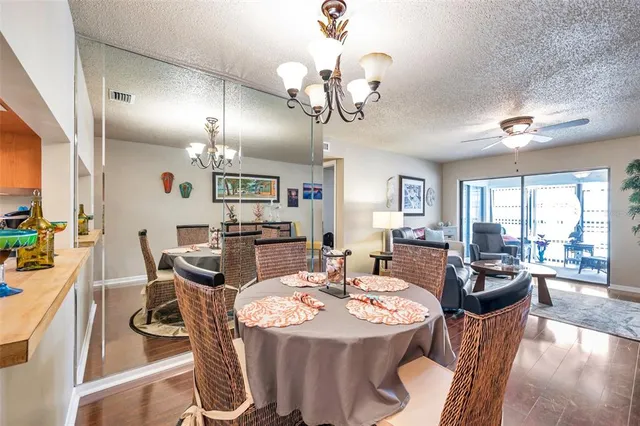 a view of a dining room with furniture a chandelier and wooden floor