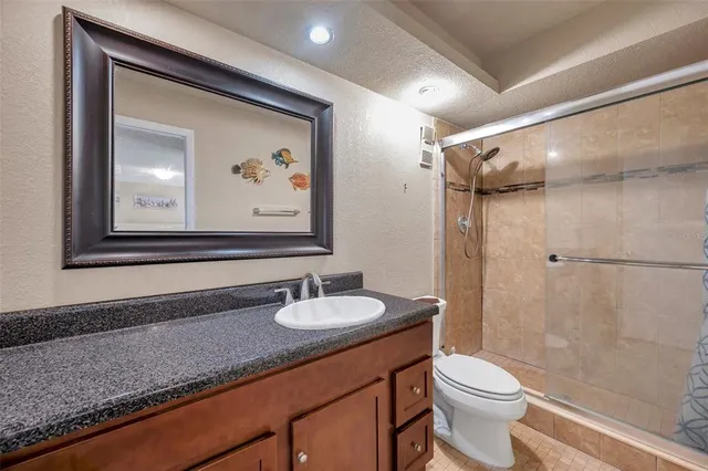 a bathroom with a granite countertop sink toilet and shower