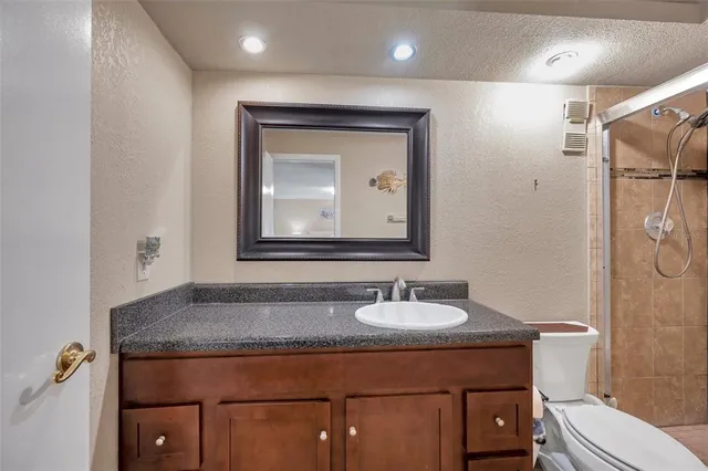 a bathroom with a toilet sink vanity and mirror