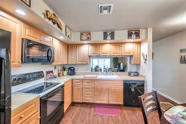 a kitchen with stainless steel appliances sink stove top oven and cabinets