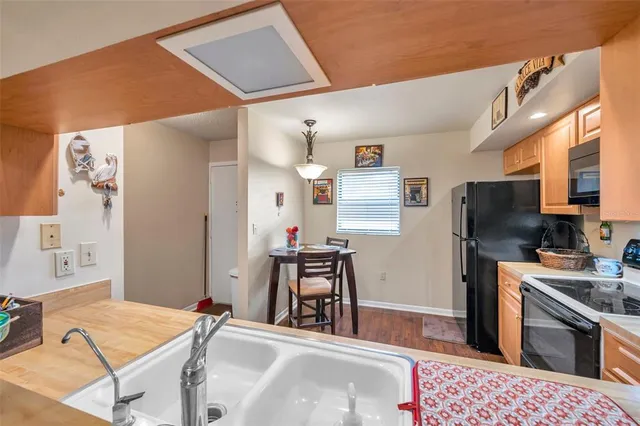 a kitchen with stainless steel appliances kitchen island granite countertop a refrigerator and a stove top oven