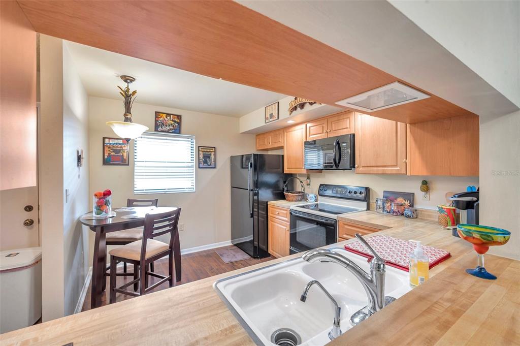 2700 Nebraska Avenue, Unit 3201 Palm Harbor, FL 34684 - Photo 10 of 50 a kitchen with stainless steel appliances granite countertop a stove top oven a sink dishwasher and cabinets with wooden floor